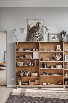 a living room filled with lots of furniture and bookshelves on top of wooden shelves