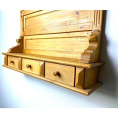 a wooden wall shelf with drawers on it