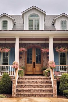 a house with steps leading up to the front door and flowers on the side of it