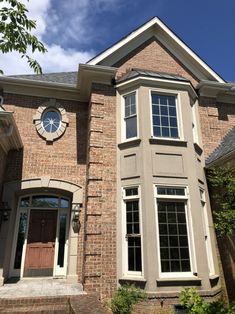 a large brick house with a clock on the side of it's face and windows