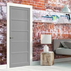 a room with brick walls and a gray door