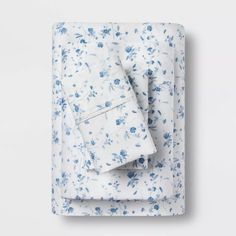 the blue and white floral sheets are folded on top of each other