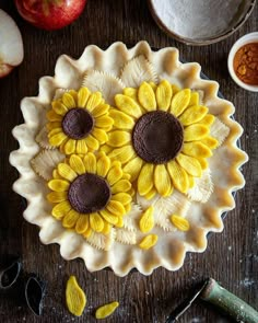 sunflowers in a pie pan on a table next to an apple and other ingredients