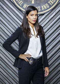 a woman is standing in front of a wall with the seal of approval on it