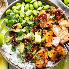 a bowl filled with chicken and rice next to two bowls of peas, avocado and limes