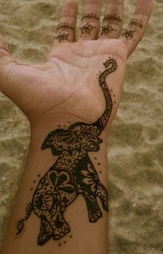 a person's hand with an elephant tattoo on it