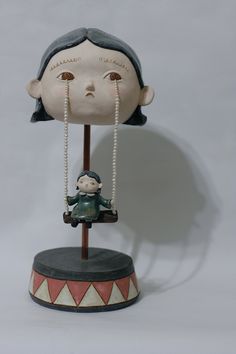 a statue of a person with a necklace hanging from it's head, on top of a base