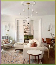 a living room filled with furniture and a chandelier hanging over the top of it