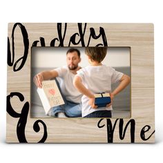 a wooden frame with the words daddy and me printed on it, in black ink