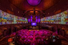 the inside of a building with many tables and chairs set up in front of large screens