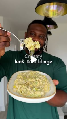 a man eating food from a white bowl with a spoon in his hand and the words leek & cabbage on it