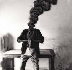 a person sitting on a bench with a pipe coming out of their head and hair in the air