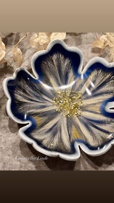 a blue and white flower sitting on top of a table