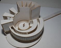 a paper model of a building on top of a white table with scissors next to it