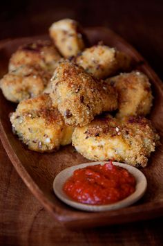 some fried food on a wooden plate with ketchup