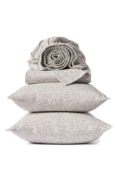 three pillows stacked on top of each other with a rolled up flower in the middle