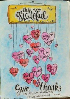 a book with hearts hanging from strings and the words give thanks written in pink ink