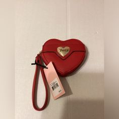 a red heart shaped purse sitting on top of a white counter next to a tag