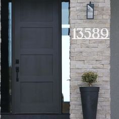 a black door with the number 1388 on it and a planter next to it