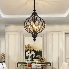 a chandelier hanging from the ceiling in a room with white walls and chairs