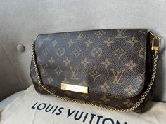 Overview Louis Vuitton Favorite MM in Monogram Canvas with gold hardware. The larger of the two sizes of the Favorite, the MM is perfect for carrying the essentials for day to evening use. Can be carried as a clutch, as a short-shoulder bag using the golden chain, or carried casually cross body using the detachable shoulder strap. The engraved front plate conceals a secure magnetic closure. Now discontinued, this popular style is only available on the market. Features Monogram coated canvas and natural leather trim Shiny gold hardware Magnetic flap closure Inside flat pocket Non removable chain strap (only one side is removable with a clip) Red Textile lining Removable leather strap Condition Exterior: Good to very good condition with some general signs of wear. Small marks to canvas, some Gold Bag With Gold-tone Logo Plaque And Double Handle, Monogram Canvas Crossbody Shoulder Bag With Gold-tone Hardware, Leather Crossbody Flap Bag With Gold-tone Logo, Luxury Crossbody Flap Bag With Gold-tone Logo, Louis Vuitton Favorite Mm, Leather Bags With Gold-tone Logo Plaque And Double Handle, Favorite Mm, Red Textiles, Mm Monogram