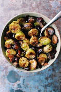 a bowl filled with brussel sprouts on top of a blue table