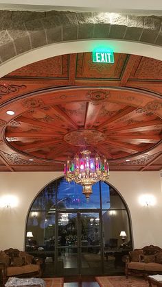 the entrance to an exit with chandelier and couches in front of it