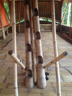 bamboo poles are stacked on top of each other in the middle of a room with wood flooring