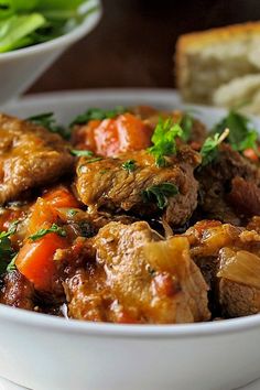 a white bowl filled with meat and vegetables