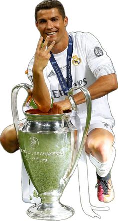 a man sitting on top of a soccer trophy with his hand up to his face