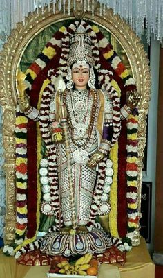 the statue is decorated with flowers and fruit