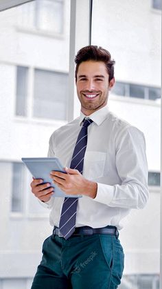 a man in a white shirt and tie is holding a tablet while smiling at the camera