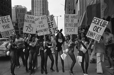 a group of women holding up signs in the street