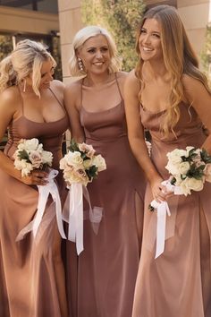 three beautiful women standing next to each other wearing brown dresses and holding bouquets in their hands