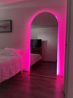 there is a bed with pink lights in the room