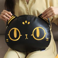 a woman holding a black cat purse with yellow eyes