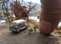 a miniature van is parked next to a tiny bike on the side of a road