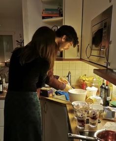 a man and woman preparing food in a kitchen