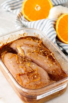 an image of food in a container with oranges and garlic on the side for garnish