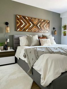 a bedroom with a bed, nightstands and paintings on the wall above it's headboard