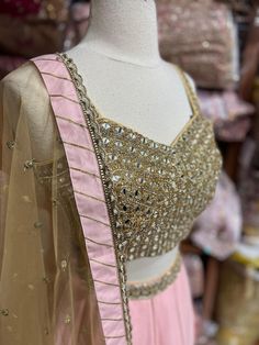 Featuring a millennial pink designer frill ruffle lehenga intricate with gotta lace, cut dana and mirror work lehenga. Completed look with contacting golden mirror, zari thread, stone and cut dana embroidered blouse and net dupatta. Fabric: Georgette This outfit can be customized in multiple colors and specific to client measurements. 120 days of production time is required and are for bulk orders only!Order are processed in store only! Final fittings/alterations not included. Minimum Order Quan Pink Party Wear Pre-draped Saree With Mirror Work, Pink Gota Work Choli For Reception, Pink Party Wear Choli With Cutdana, Gold Anarkali Set With Mirror Work For Party, Gold Lehenga With Mirror Work For Party, Pink Kundan Sets With Cutdana, Pink Floor-length Saree With Gota Work, Festive Pink Choli With Dabka Work, Pink Floor-length Pre-draped Saree With Dori Work