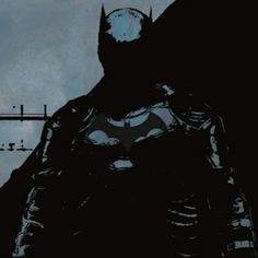 the silhouette of a batman standing in front of a clock tower