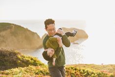 a man carrying a young boy on his back while he is holding the child up in the air