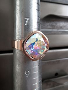 Romantic, other-worldly color... This dazzling Swarovski crystal cocktail ring has a 'Crystal AB' cushion-cut square stone... forever-sparkling crystal with soft, pastel flashes of every color in the rainbow, with a sheer, shimmering iridescent finish. The perfectly-faceted Swarovski cushion-cut crystal is set into a beautiful, high-quality, shiny light rose gold plated adjustable ring with an elegant, modern square bezel. Cushion-cut Swarovski crystal: 12mm dia (1/2") Shiny soft rose-gold plate Elegant Crystal Jewelry, Swarovski Crystal Rings, Square Stone, Soft Rose, Modern Square, Chic Jewelry, Crystal Ab, Rose Lights, Sparkling Crystal