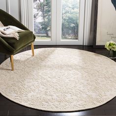 a large white rug in the middle of a room next to a chair and window