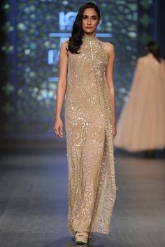 Symbolic of ingenuity and originality, this scintillating, uber-glamorous gold gown is decked with intricate sequin embroidery. Boasts of a halter neckline, this swoon-worthy addition ensures breathtaking access.
No of components: 1
sequin embroidery
Overlay detail
Halter neck
Sleeveless
Closure: Keyhole back with hook - Aza Fashions Halter Neck Gown, Clothes Swap, Gown Gold, Gold Gown, Embellished Gown, Gowns Online, Designer Gowns, Bridal Lehenga, Ethnic Wear