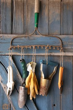 an old coat rack with gardening tools hanging from it's hooks on a wooden wall