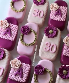 some pink and purple decorated cell phones with flowers on them are sitting next to each other