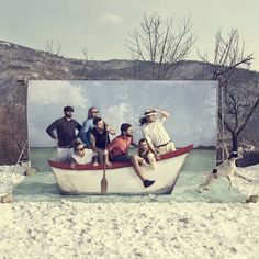 a group of people sitting on top of a boat in the snow