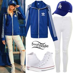 a woman in white pants and blue jacket with adidas hat on the left side